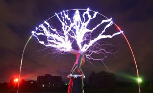 The guitarist of the band "Lightningfan" Wang Hongbin (C) creates lightning with a Tesla Coil in their village outside of Fuzhou in China's Fujian province on June 24, 2013. The Tesla Coil invented by Nikola Tesla in 1891 is a transformer that produces vast amounts of voltage at high frequencies that creates long bolts of electricity like lightening. Inventor and founding member of the band Wang Zengxiang, an electrical engineer made his first Tesla Coil in 2007 and afterwards formed his 10 member band who, whilst wearing ferroalloy metal suits play guitars, violins and drums with bolts of lightening crackling from them and their instruments to the beat. AFP PHOTO/Peter PARKSPETER PARKS/AFP/Getty Images
